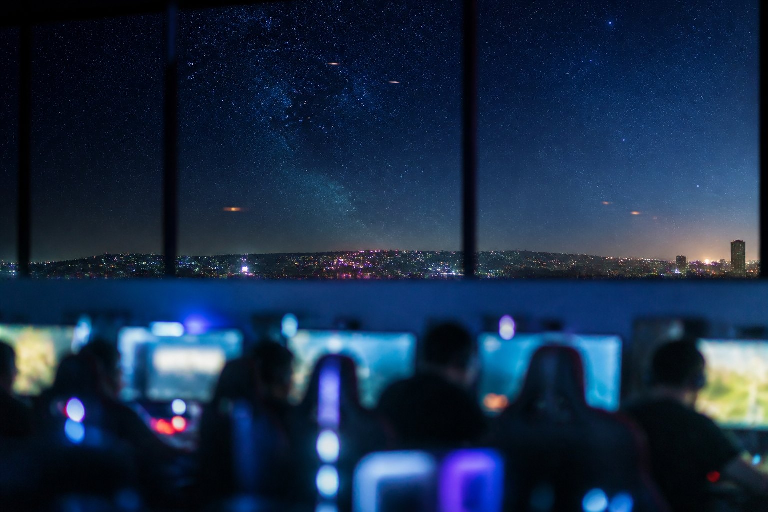 Long panoramic window along a row of gaming stations at dusk